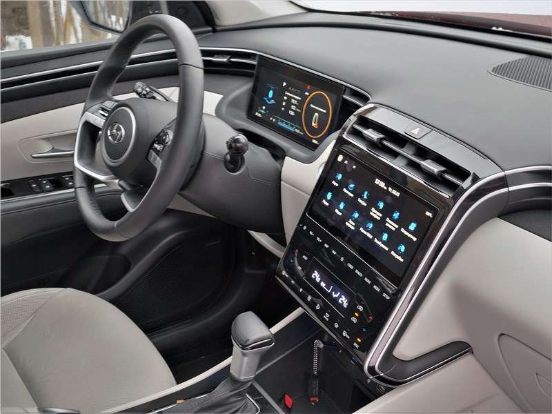 Фото Hyundai Tucson - Посмотрим на водительский кокпит с места переднего пассажира. Обратите внимание: над комбинацией приборов нет традиционного козырька, ни в каком его виде