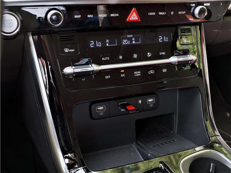 Фото KIA Carnival - Вид центральной консоли. Глянцевый пластик придает интерьеру дорогой вид, однако требует постоянной протирки