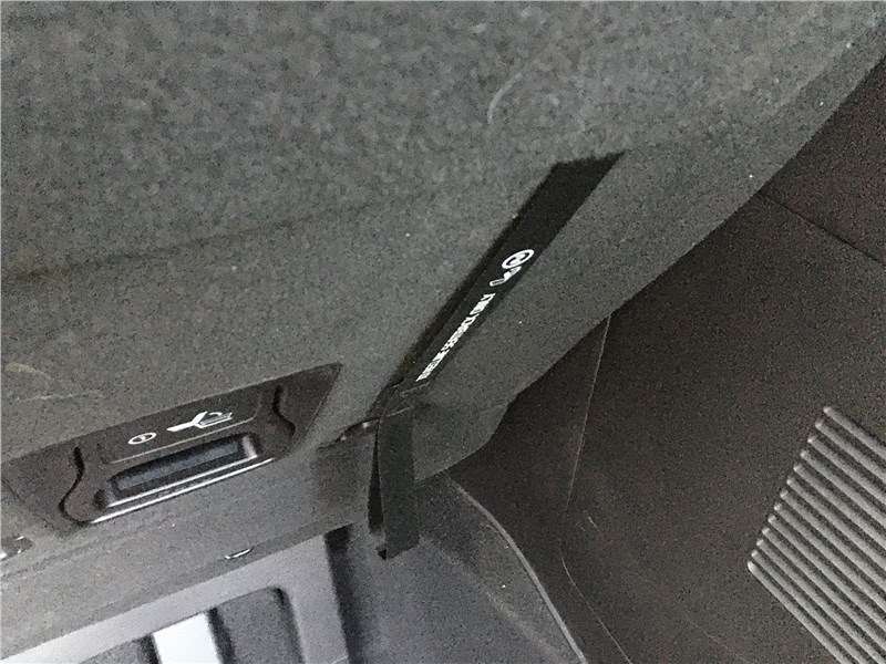 Фото KIA Carnival - Лямки, за которые надо тянуть, чтобы сложить кресла третьего ряда, крепятся к спинкам липучками