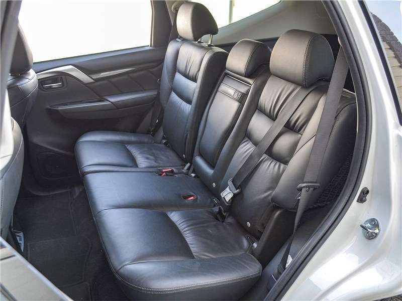 Фото Mitsubishi Pajero Sport - Сзади, в целом, просторно, но вот потолок, как и спереди – нависает. Пространства для ног хватает, есть возможность регулировки положения спинки кресла, присутствует подлокотник с подстаканниками…