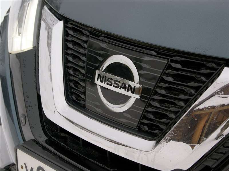 Фото Nissan X-Trail - Фирменная эмблема теперь закрыта прозрачной гладкой пластиной, это, пожалуй, самое заметное отличие обновленной версии кроссовера от предыдущей