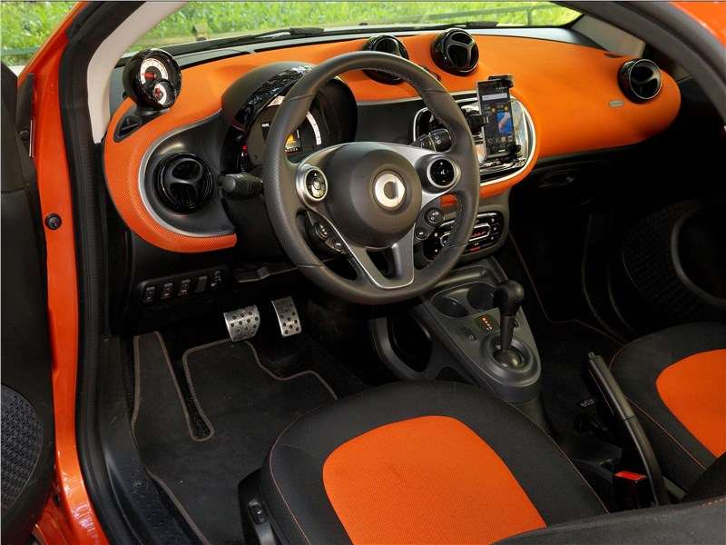 Фото Smart Fortwo Coupe - Оранжевые вставки в салоне гармонируют с цветом кузова. Но долго ли в наших условиях эта ячеистая ткань будет оставаться целой и чистой?