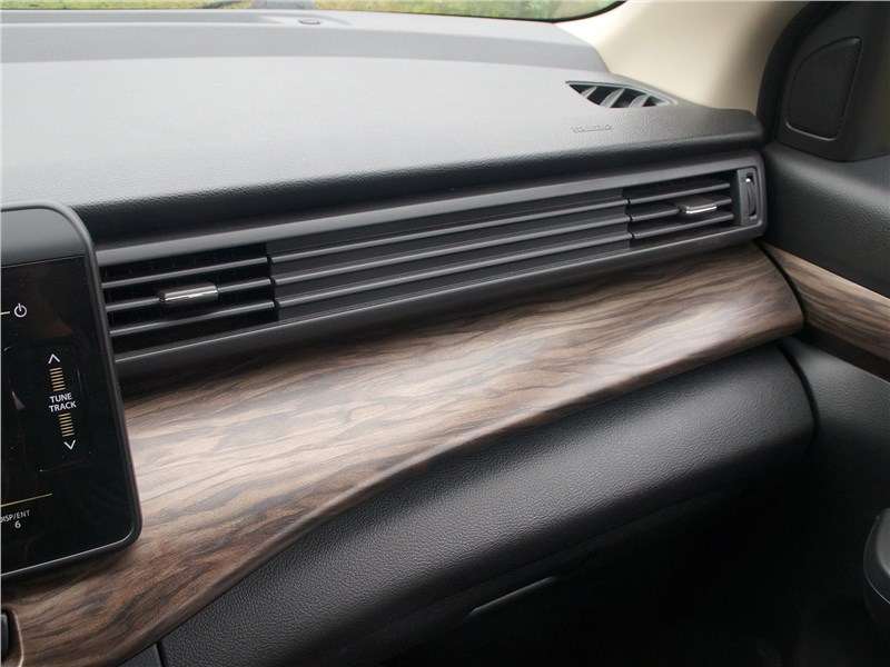 Фото Suzuki Ertiga - Вставки под дерево на торпедо и внутренних панелях дверей — абсолютно лишняя «роскошь». Однако выполнены они деликатно и аляповатыми не выглядят