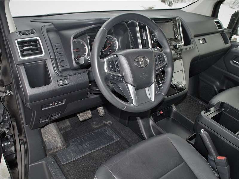 Фото Toyota Hiace - Для оформления передней части салона выбран классический стиль. Дизайн напоминает минивэн Alphard, но есть и отличия от него